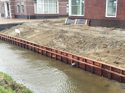 Beschoeiing en Damwand
Een walbeschoeiing of damwand is een constructie die wordt gebouwd langs de rand van een sloot, rivier of meer. Het wordt gemaakt om de aarde of het zand van de oever op zijn plaats te houden en te voorkomen dat het in het water valt. Op die manier helpt het bij het beschermen van de grond tegen erosie en voorkomt het dat de oever afbrokkelt. Het kan van verschillende materialen gemaakt zijn, zoals houten planken, stenen of beton.
Keywords: Beschoeiing,Damwand